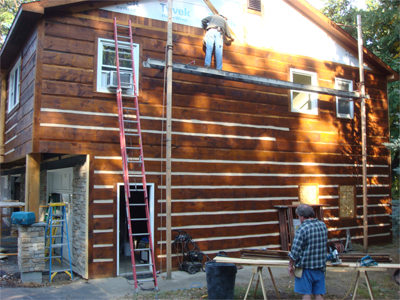 contractors applying chinking to a log home