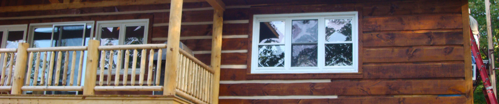 log home chinking applied by contractor standing on ladder